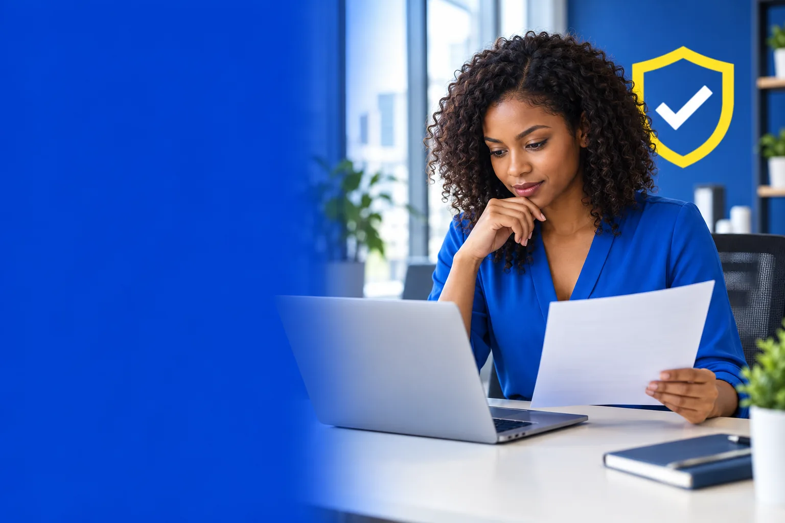 A professional carefully reviewing a job application on a laptop beside a yellow verification graphic.